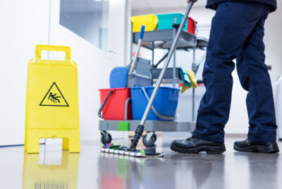 Worker janitor Mopping Floor In Office with trolley